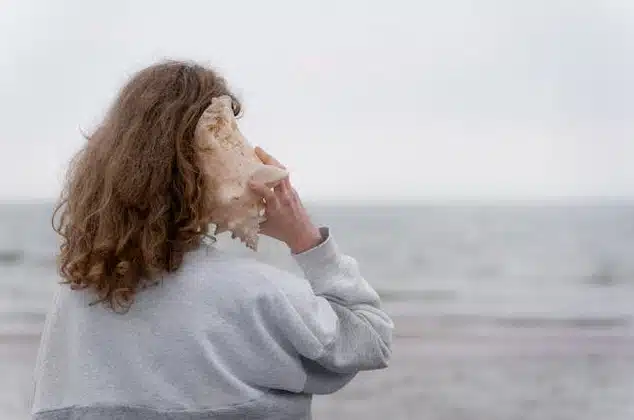 Woman with conch shell to her ear